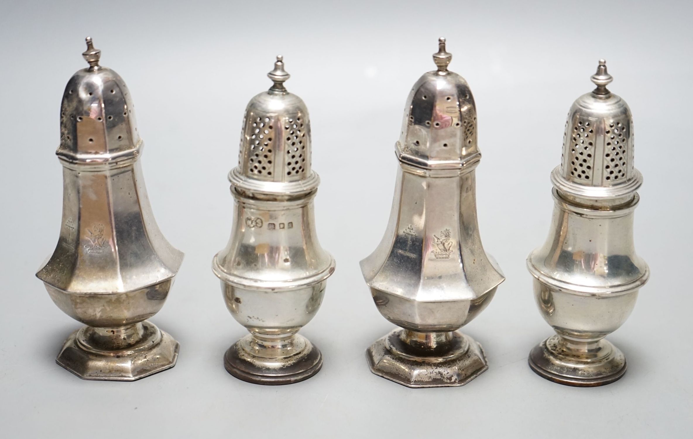 A pair of late Victorian silver panelled pepperettes, London, 1900 and a later pair, London, 1931, 232 grams.